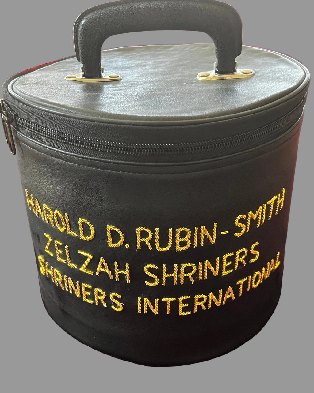 Black zippered carry case with top handle and gold Harold D. Rubin-Smith, Zelzah Shriners and Shriners International embroidery, photographed on burgundy fabric