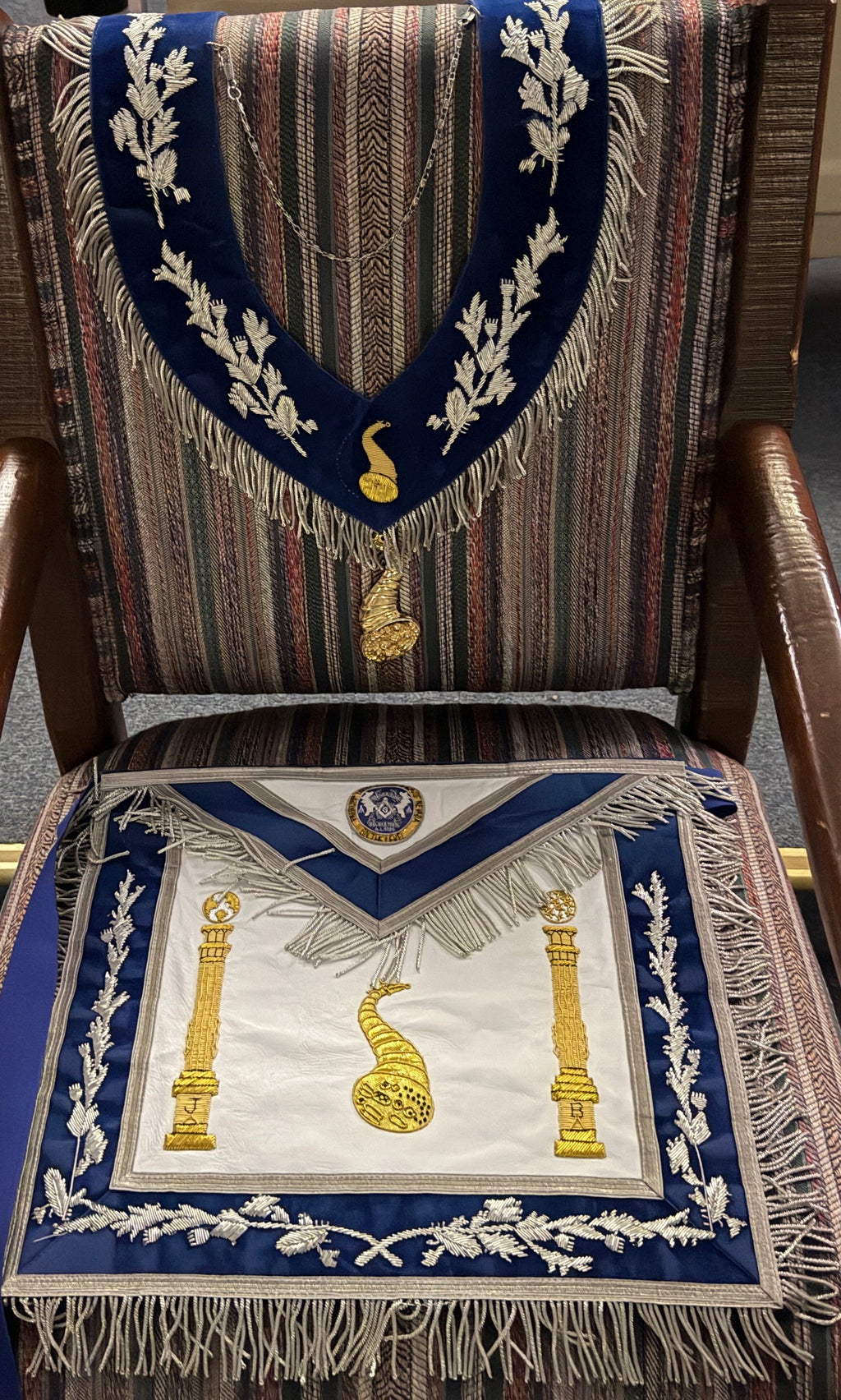 Blue and white officer apron and matching collar featuring a gold-colored cornucopia emblem